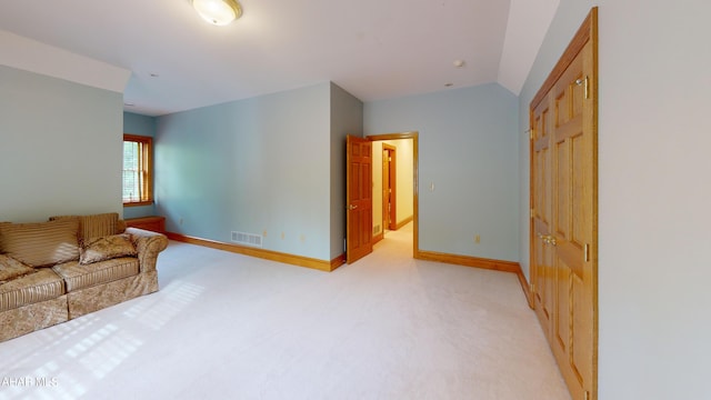 living room featuring light carpet, baseboards, and vaulted ceiling