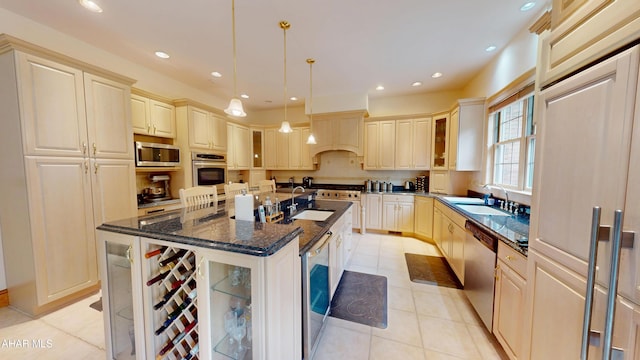 kitchen featuring a sink, appliances with stainless steel finishes, a kitchen island with sink, glass insert cabinets, and recessed lighting