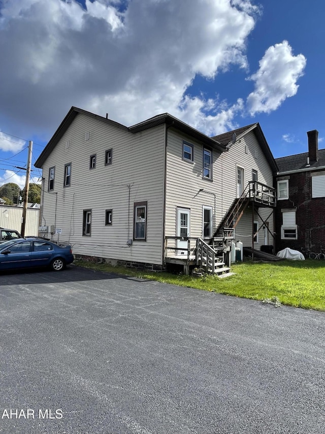 view of side of property with a wooden deck and a lawn