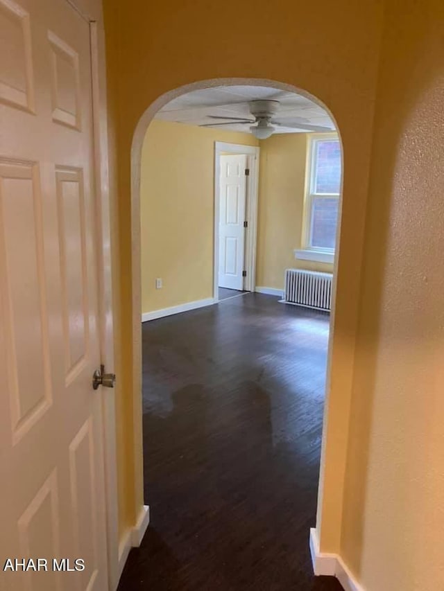 hall with radiator and dark wood-type flooring