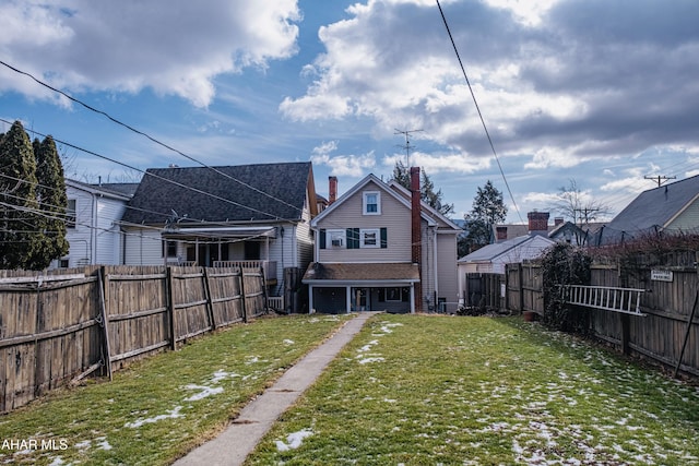 rear view of house featuring a lawn