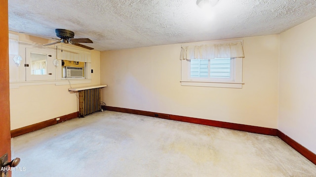 carpeted spare room featuring cooling unit, ceiling fan, radiator heating unit, and a textured ceiling