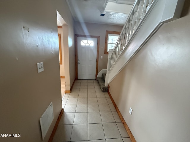 doorway to outside with baseboards, stairs, and light tile patterned floors