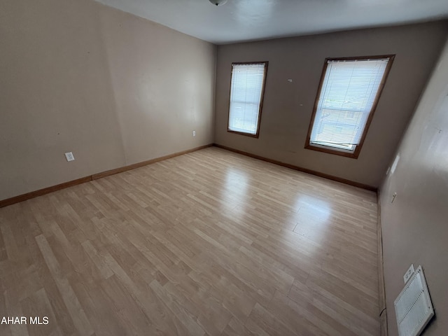 empty room with light wood-style floors and baseboards