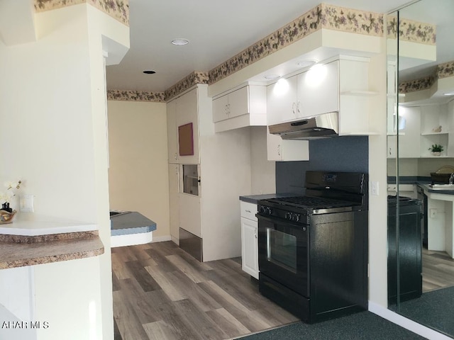 kitchen featuring under cabinet range hood, white cabinetry, baseboards, black range with gas cooktop, and dark wood-style flooring