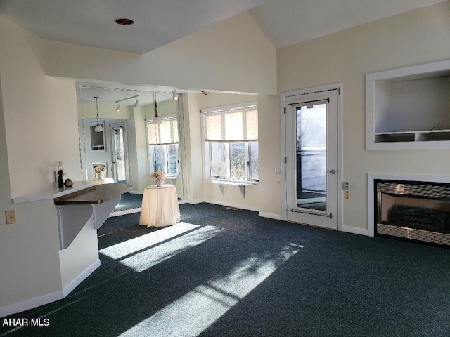 unfurnished living room with dark colored carpet and lofted ceiling