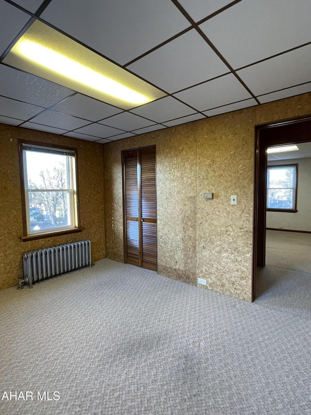 carpeted spare room with radiator heating unit