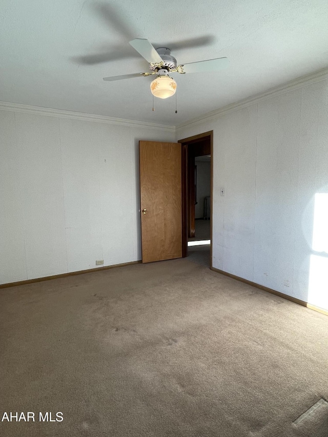 empty room with carpet, ceiling fan, and crown molding