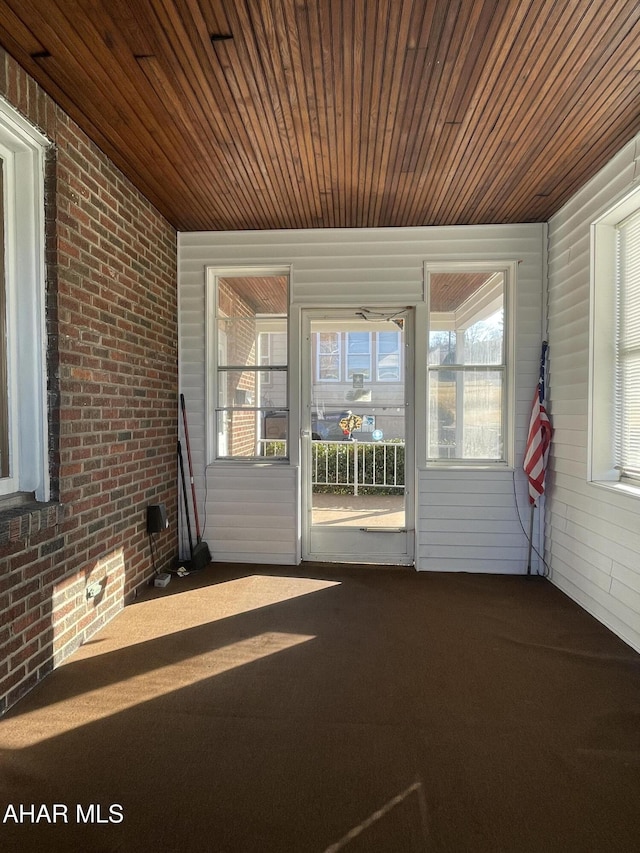 unfurnished sunroom featuring wood ceiling