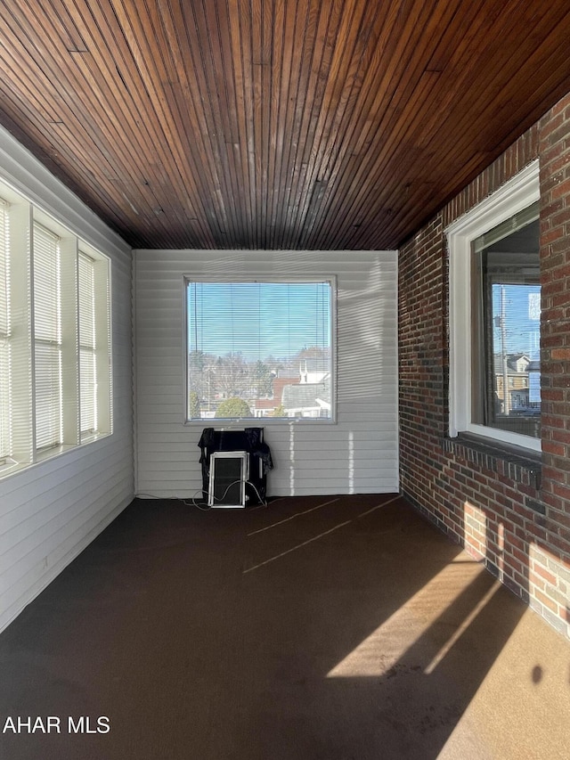 unfurnished sunroom featuring wood ceiling