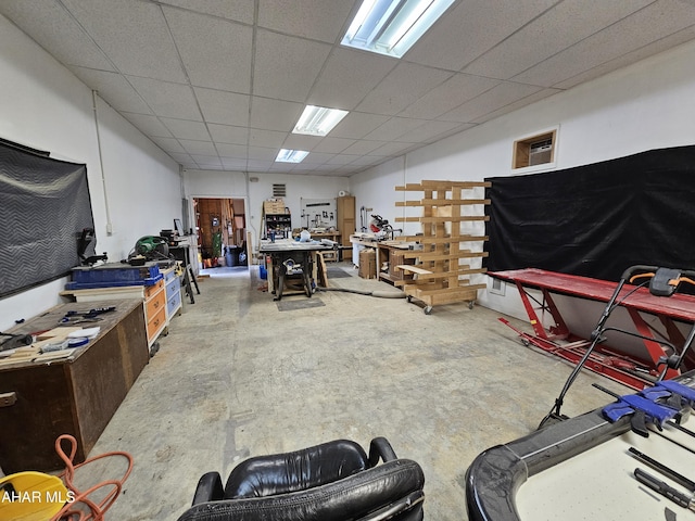 interior space with a workshop area and a paneled ceiling