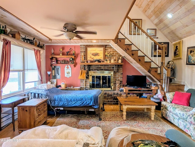 bedroom with a brick fireplace, wood ceiling, wood-type flooring, and vaulted ceiling