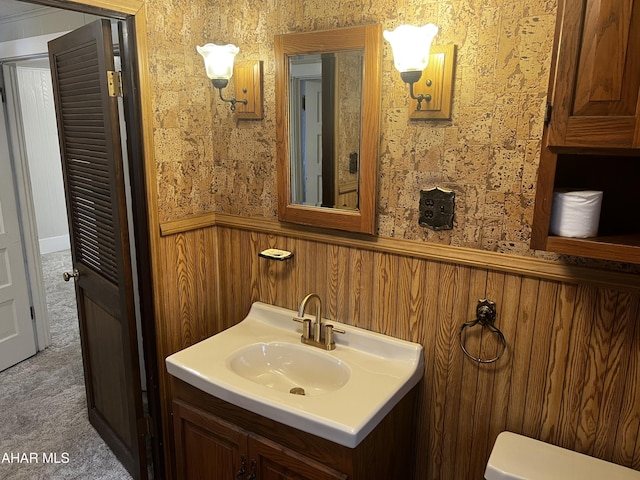 bathroom with a wainscoted wall, vanity, and wallpapered walls