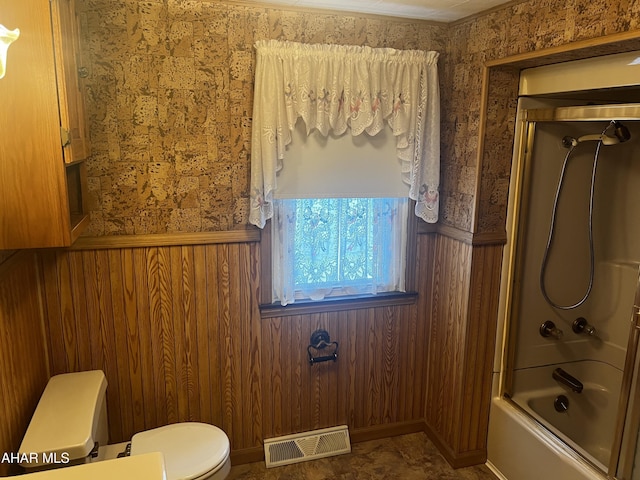 full bathroom featuring toilet, a wainscoted wall, enclosed tub / shower combo, and visible vents