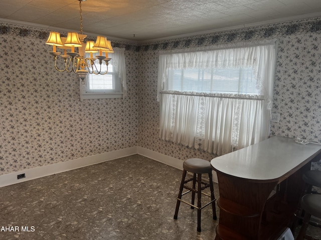 unfurnished dining area with baseboards, crown molding, and wallpapered walls