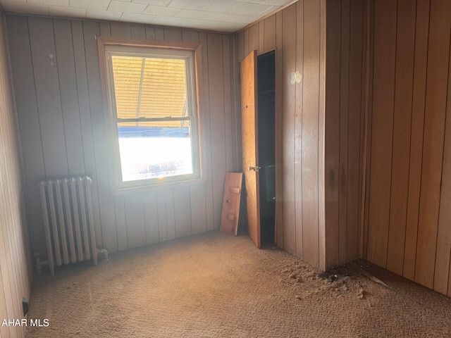 carpeted spare room featuring radiator heating unit