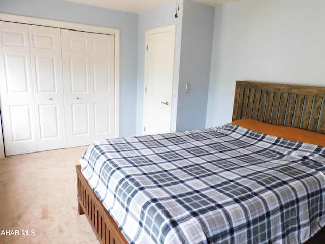 bedroom with light colored carpet and a closet