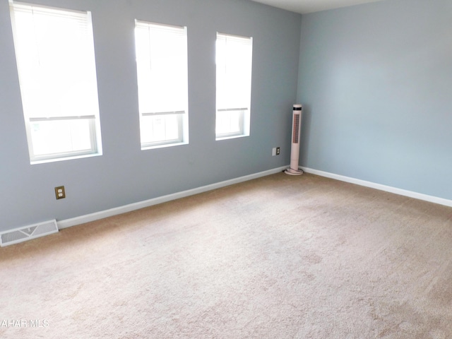 carpeted spare room featuring plenty of natural light