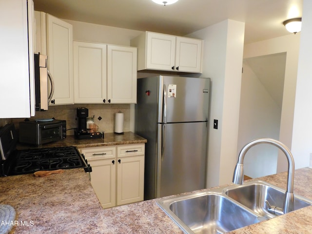 kitchen featuring backsplash, white cabinetry, sink, and stainless steel appliances