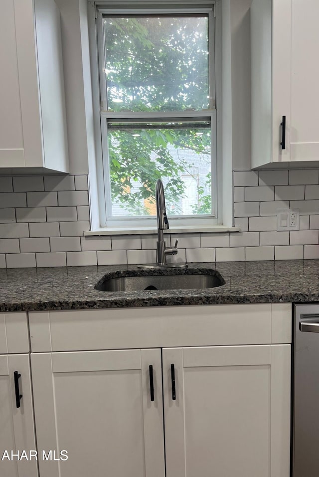 2306 5th Ave, Altoona, PA 16602 - kitchen featuring a sink, dishwasher, white cabinetry, decorative backsplash, and dark stone counters