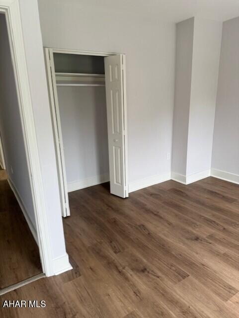 2306 5th Ave, Altoona, PA 16602 - unfurnished bedroom featuring a closet, wood finished floors, and baseboards