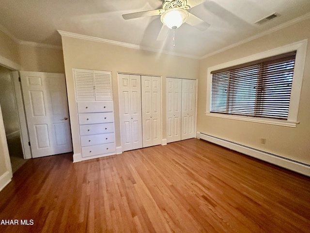 3405 Crescent Rd, Altoona, PA 16602 - unfurnished bedroom featuring ornamental molding, wood finished floors, two closets, a baseboard heating unit, and a ceiling fan