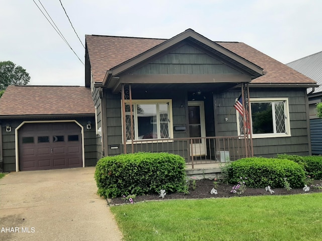 735 N Julian St, Ebensburg, PA 15931 - view of front of home featuring a shingled roof, an attached garage, a porch, concrete driveway, and a front lawn