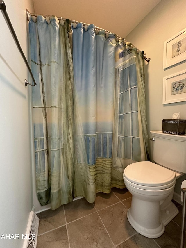 bathroom with curtained shower, tile patterned flooring, and toilet