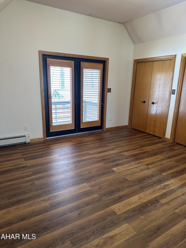 unfurnished bedroom featuring two closets, dark wood-style floors, a baseboard radiator, baseboards, and vaulted ceiling