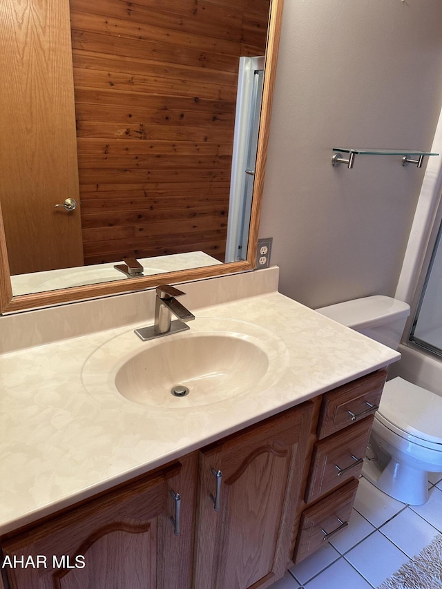 full bath with tile patterned flooring, toilet, vanity, and walk in shower