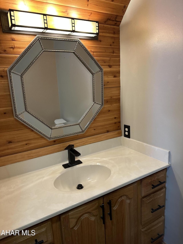 bathroom featuring vanity and wooden walls