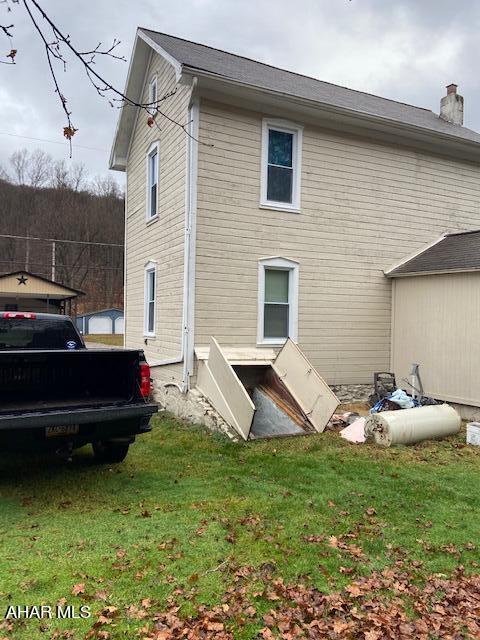 rear view of house featuring a yard