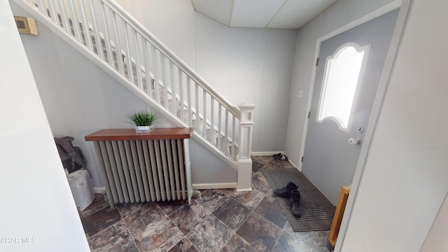 foyer entrance with radiator heating unit and a paneled ceiling