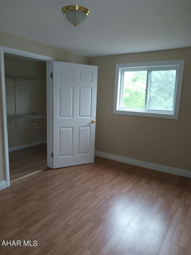 unfurnished bedroom featuring hardwood / wood-style floors and a closet