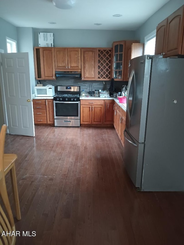 kitchen featuring decorative backsplash, dark wood-type flooring, and appliances with stainless steel finishes