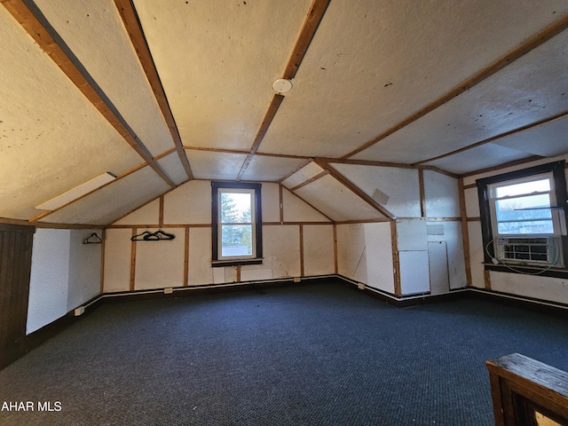 bonus room featuring vaulted ceiling, cooling unit, and dark colored carpet