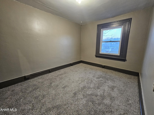 carpeted spare room featuring baseboards