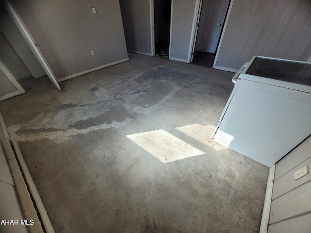 details with washer / dryer, wood walls, and unfinished concrete floors