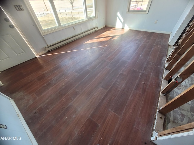 interior space featuring a baseboard heating unit and wood finished floors