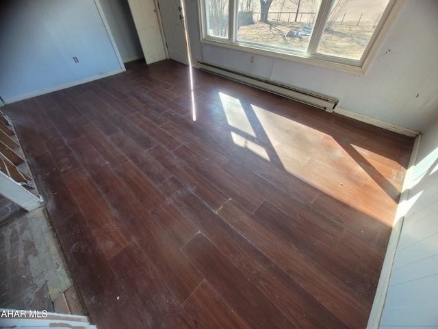 interior space featuring baseboards, baseboard heating, and wood finished floors