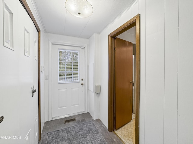 entryway featuring a textured ceiling and ornamental molding