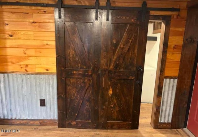 interior space featuring a barn door and wooden walls