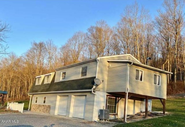 view of front facade with a garage and central air condition unit