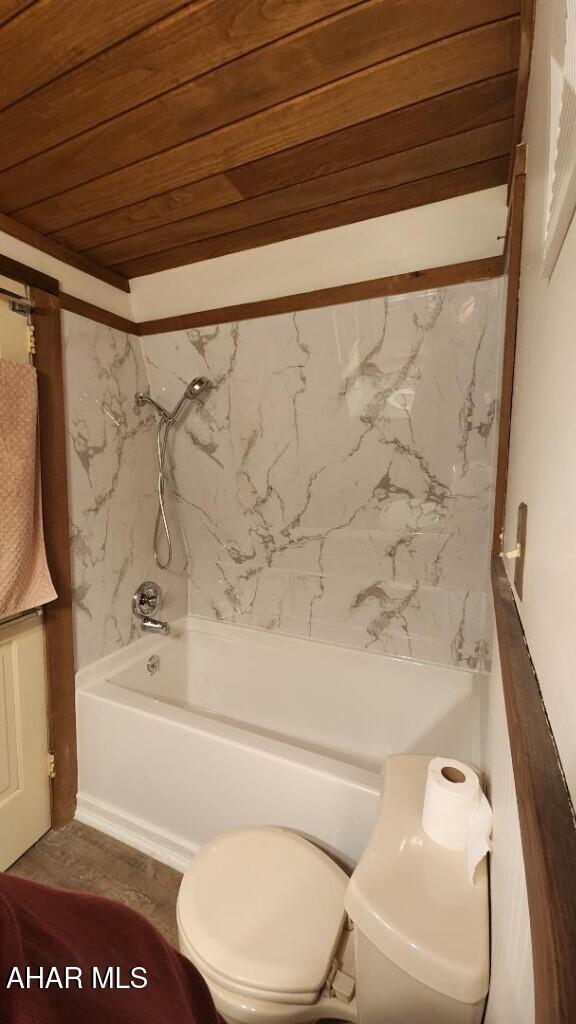 bathroom featuring shower / tub combination, wooden ceiling, and toilet