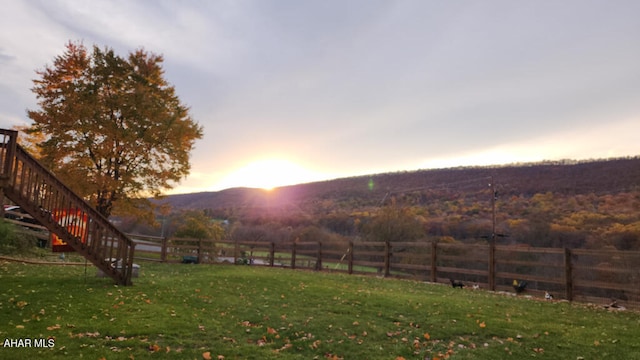 yard at dusk featuring a mountain view