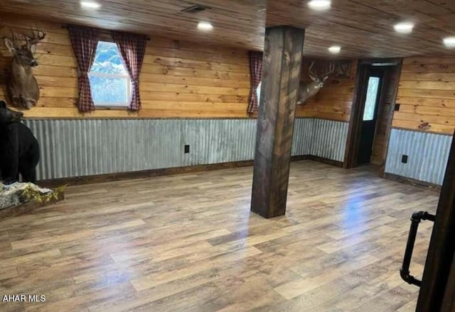 spare room with hardwood / wood-style flooring, wooden ceiling, and wood walls