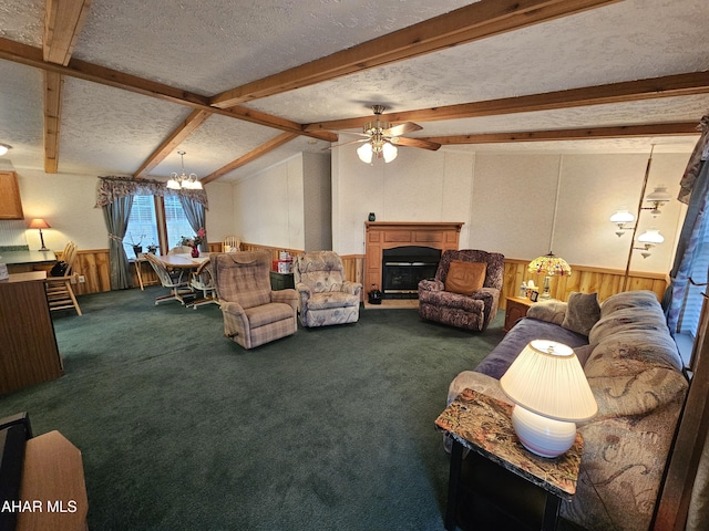 living room featuring carpet, wainscoting, a fireplace, and a textured ceiling