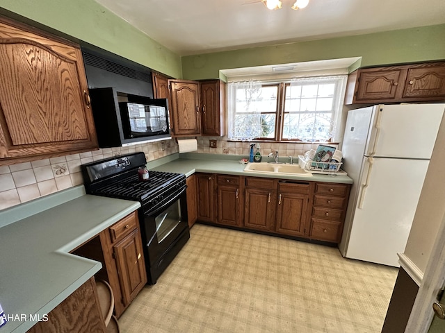 kitchen featuring sink, backsplash, and black appliances