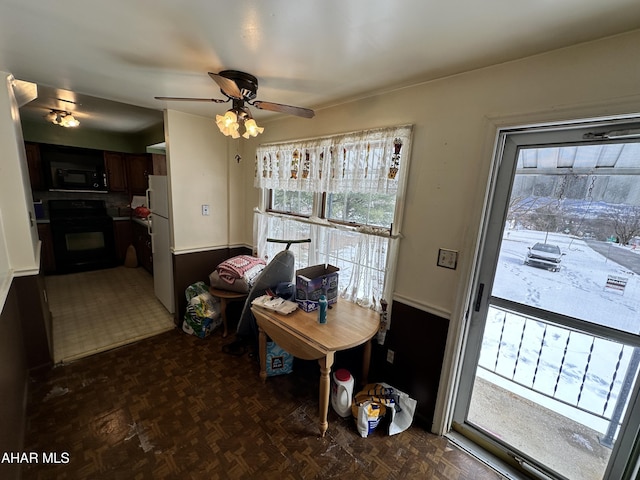 dining area with ceiling fan and dark parquet floors