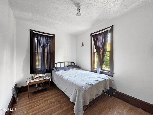 bedroom with hardwood / wood-style floors and a textured ceiling